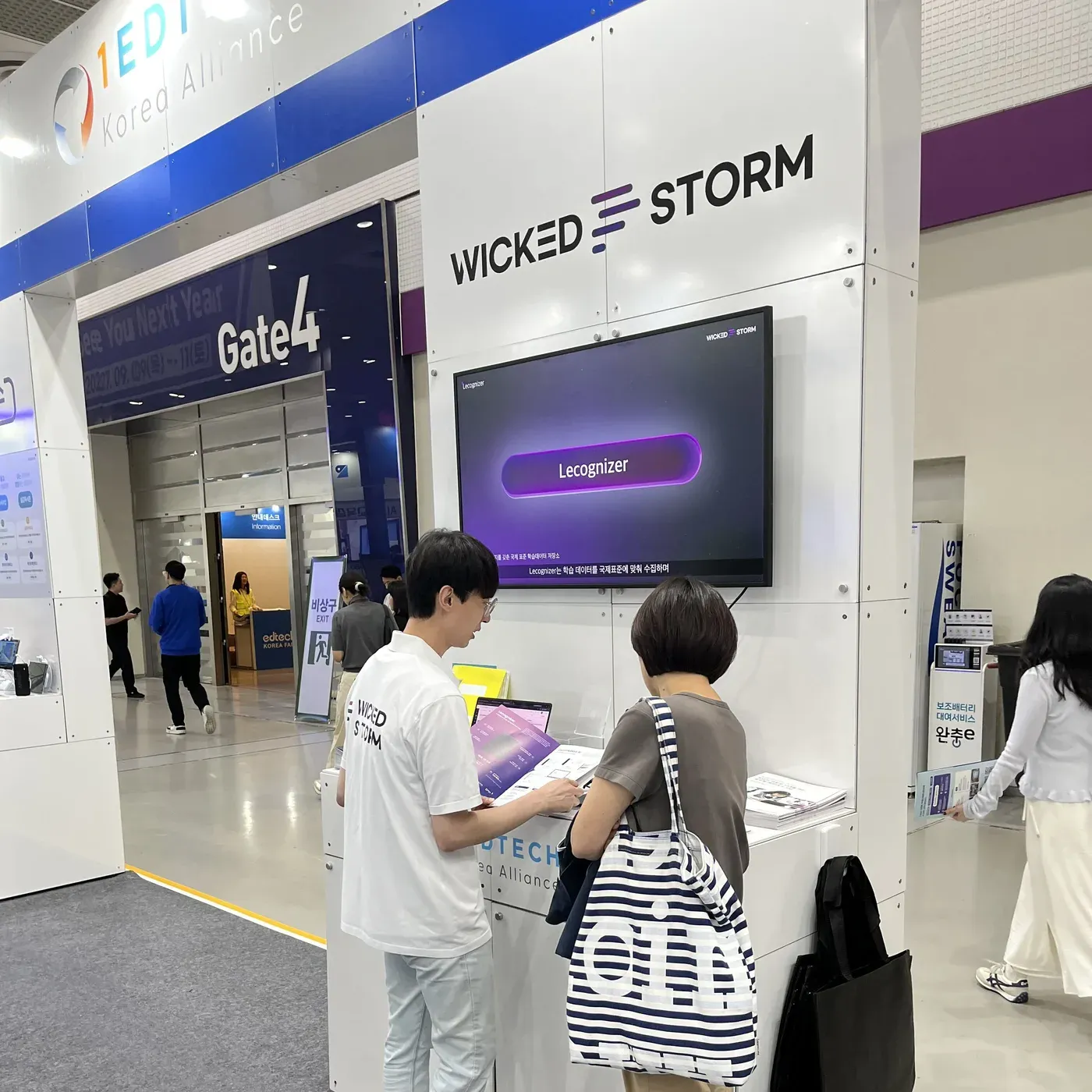 1EdTech Korea共同ブース内のWicked Stormブースで、Lecognizerの画面を映しながら来場者に製品を説明する様子